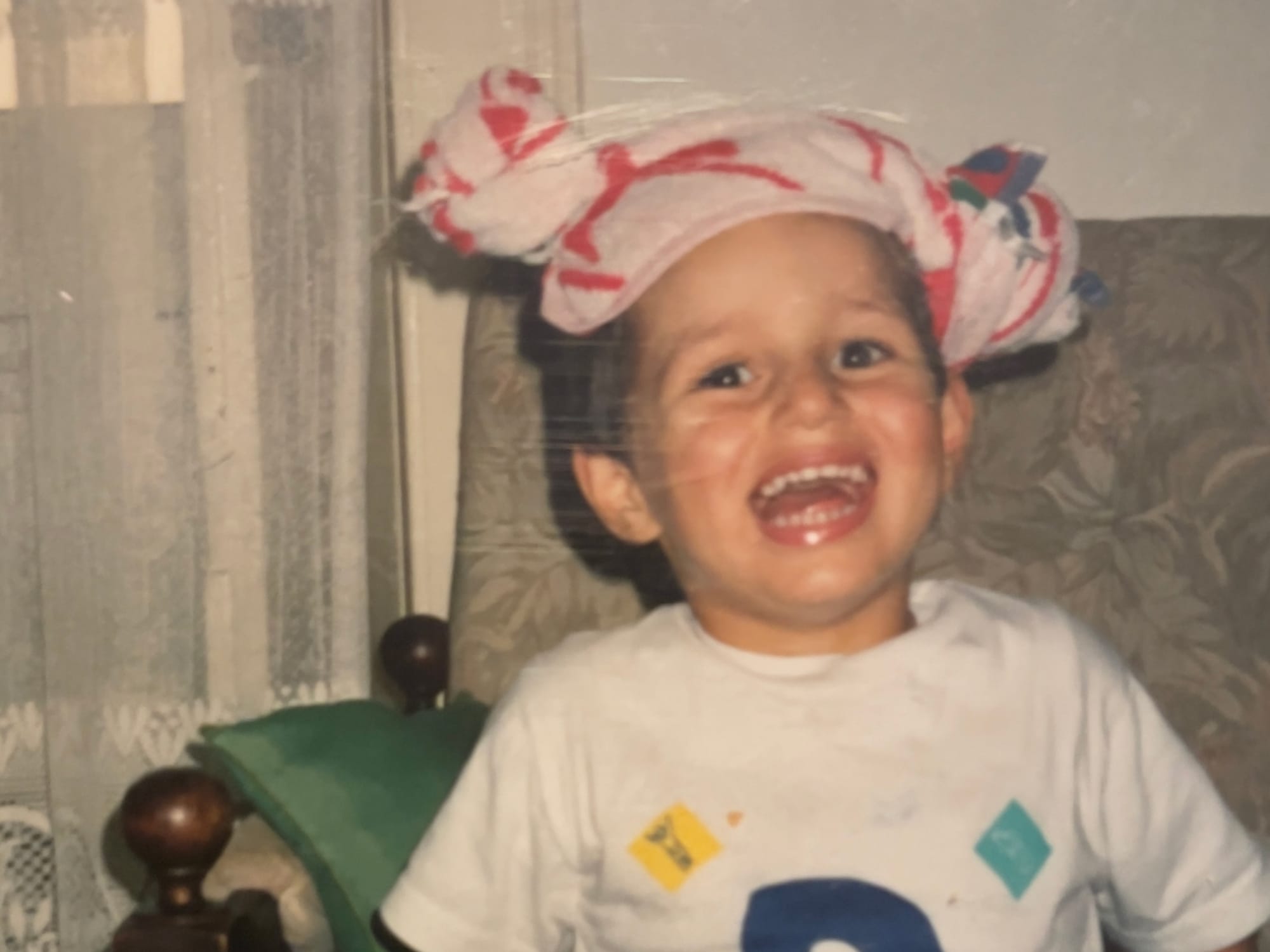 A picture of me smiling when I was a kid with a towel on my head like a turban